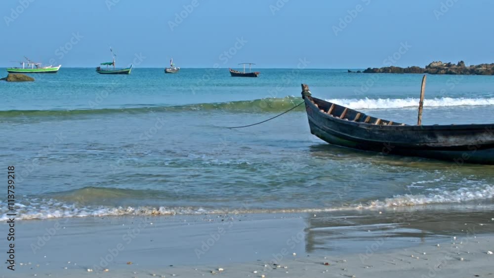 Fisherman boats on sand and anchored on the Ngapali beach panorama, Myanmar Fisherman boats on sand and anchored on the Ngapali beach panorama, Myanmar