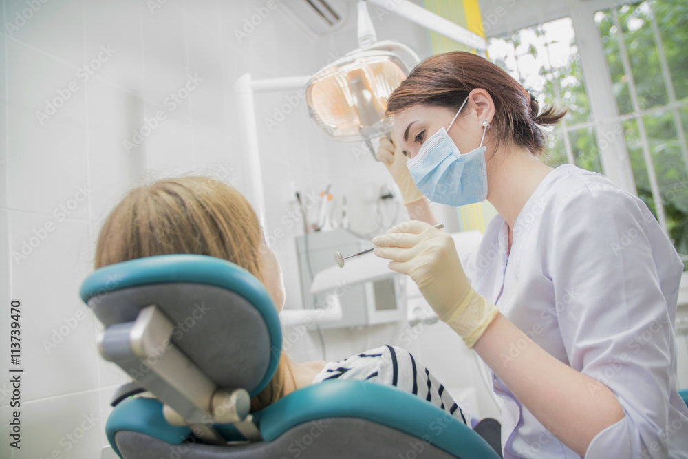 beautiful female dentist doctor, young woman doctor in a dental clinic. the dentist sits in the Cabinet beside the chair with the patient beautiful female dentist doctor, young woman doctor in a dental clinic. the dentist sits in the Cabinet beside the chair with the patient