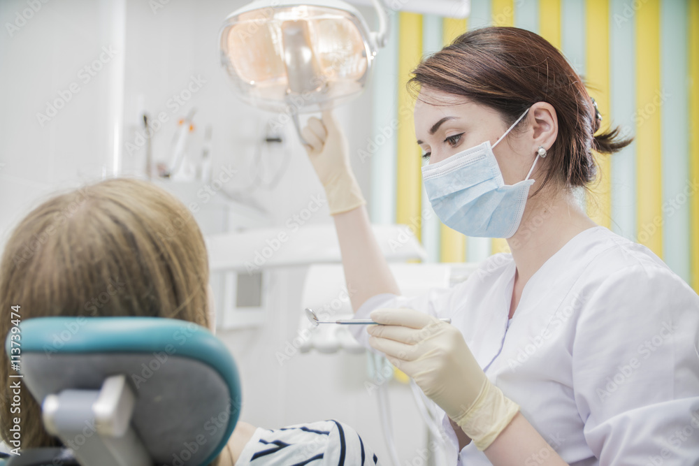 beautiful female dentist doctor, young woman doctor in a dental clinic. the dentist sits in the Cabinet beside the chair with the patient beautiful female dentist doctor, young woman doctor in a dental clinic. the dentist sits in the Cabinet beside the chair with the patient