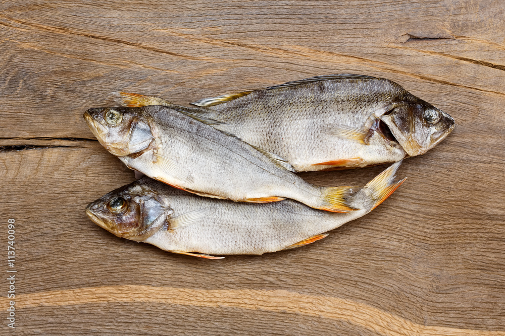 Three dried fishes on a wooden table. Three dried fishes on a wooden table.