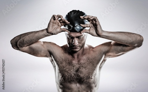 Composite image of swimmer holding goggles