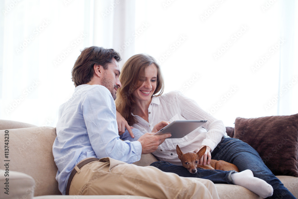 Cheerful couple using tablet Cheerful couple using tablet