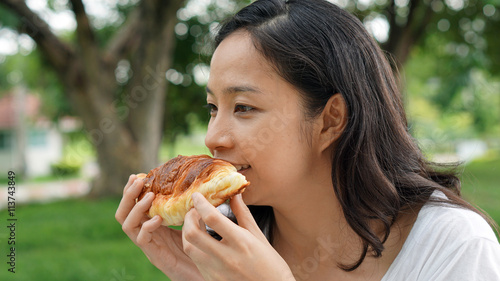Asian woman mature adult eating bread carbohydrates