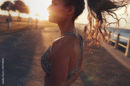 Fitness woman standing outdoors during evening