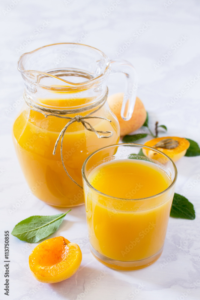 A refreshing summer drink with peach in a jug and glasses on a g A refreshing summer drink with peach in a jug and glasses on a g