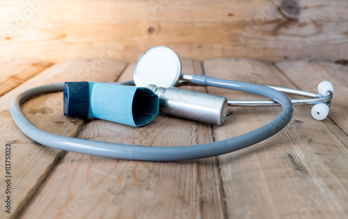 Bronchodilator inhaler ,Stethoscope and Medical equipment on wood table