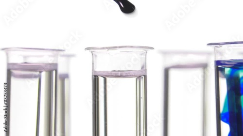 pipette depositing drops of blue dye in rotating test tubes