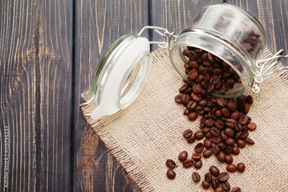 Roasted coffee beans in glass jar on wooden background Stock Photo