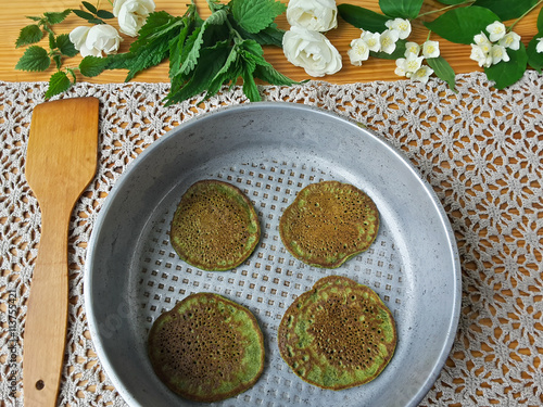 Nettles green pancakes with rose petals, cooking organic food with weed