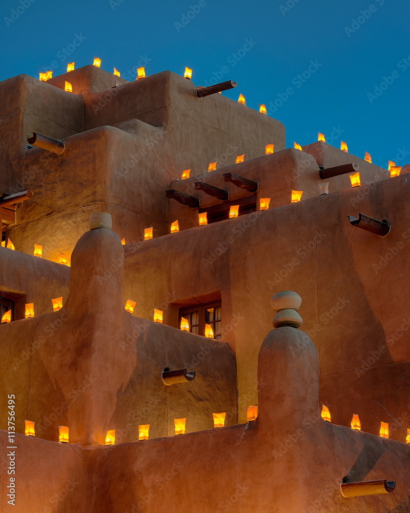 Obraz premium Duży budynek z cegły adobe ozdobiony na święta lumina- riami