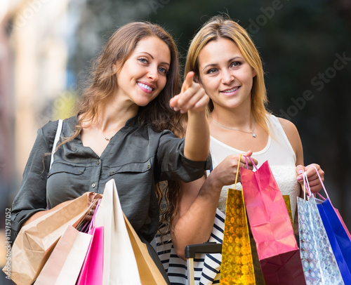 Two young women holding shopping bags.