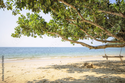 Fototapeta Naklejka Na Ścianę i Meble -  Wooden swing on tropical beach background, happy summer holiday concept 