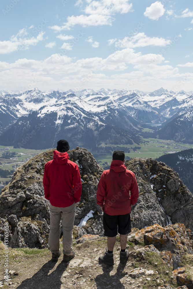 two hikers enjoying the view over the alps