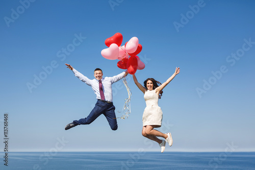 Happy wedding couple with red balloons