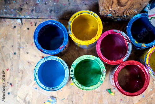 Colourful paint cans on the floor viewed from above