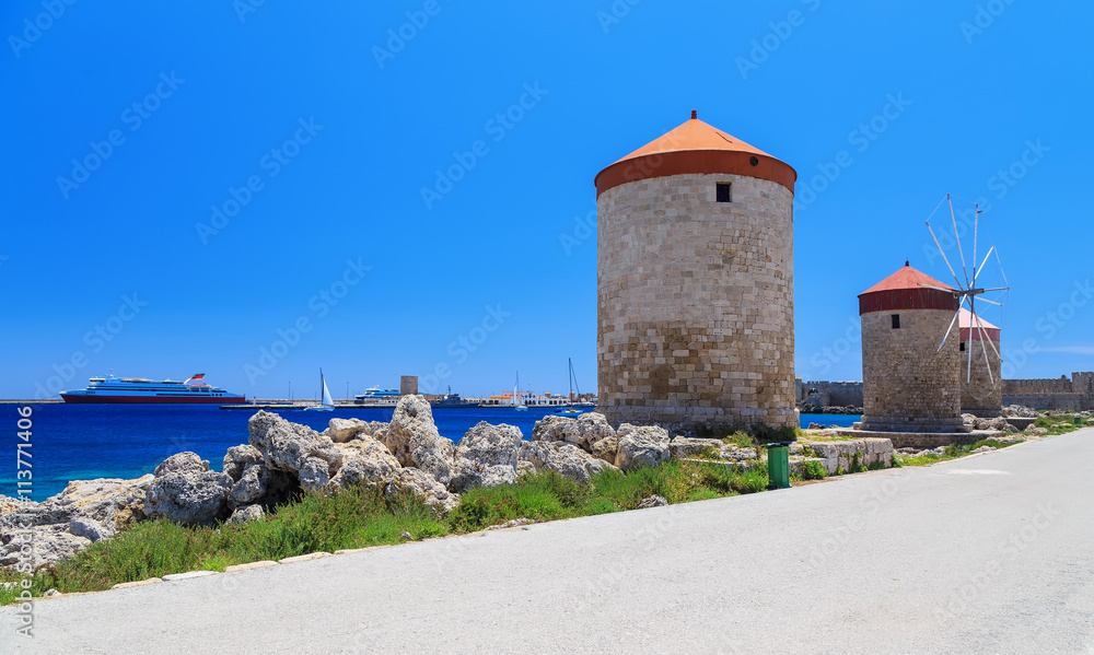 Rhodes mills on the background of the sea bay and the port sunny day Rhodes mills on the background of the sea bay and the port sunny day