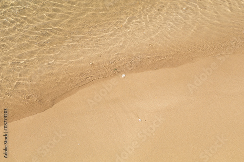 Beautiful crystal clear sea water  Gentle waves breaking on golden sand beach.  From above with copy space.