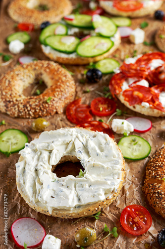 Delicious Bagel sandwiches with soft cheese, chorizo, vegetables. selected focus