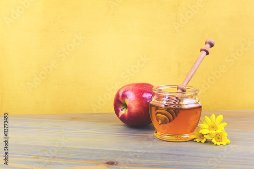 Honey jar and apple on wooden rustic table. Jewish holiday Rosh Hashanah background