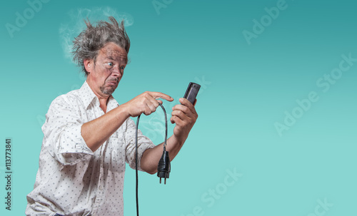 mann mit verkohltem gesicht mit defektem kabel sucht auf smartphone nach hilfe photo