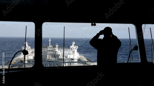 Watch officer observing around by binocular.