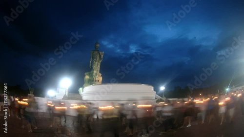 4K : People walk with candles around a large Buddha statue to celebrate Visakha Bucha Day photo