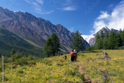 Unidentified tourists walking on the road in the Altay Mountains, Russia.
