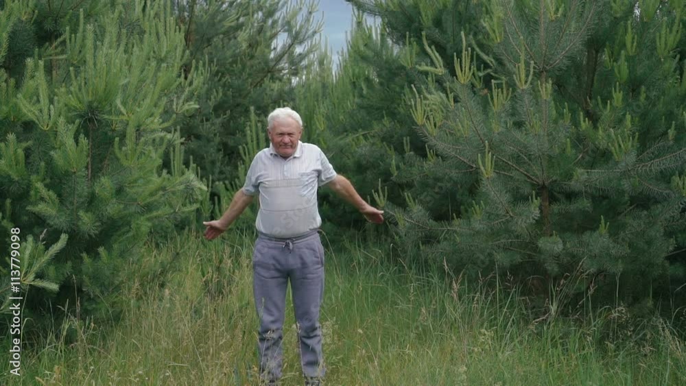 Old man does morning exercises squats up-down on the camera Old man does morning exercises squats up-down on the camera