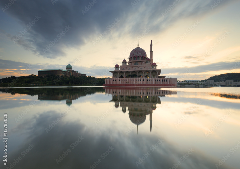 Obraz premium A reflection of clouds and mosque on a very calm morning.