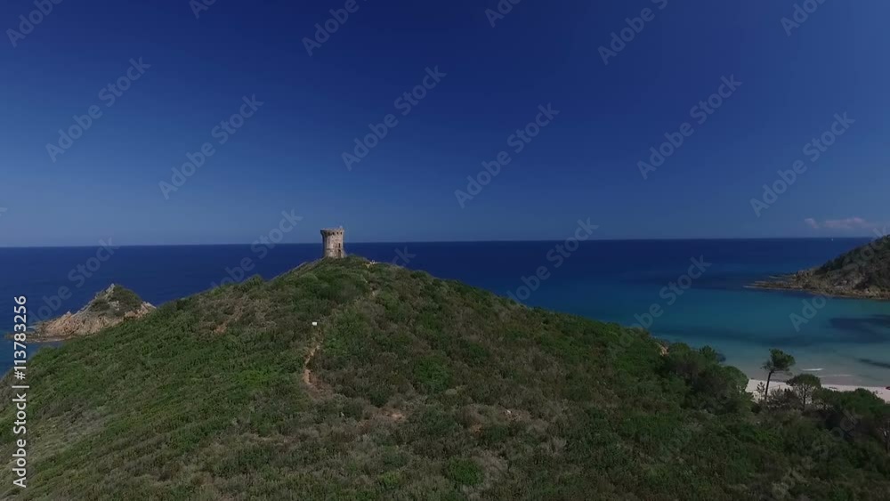 Aerial: Flight over Genoese tower on a cliff by the sea near Fautea, historical fortification system of Corsica, France Aerial: Flight over Genoese tower on a cliff by the sea near Fautea, historical fortification system of Corsica, France