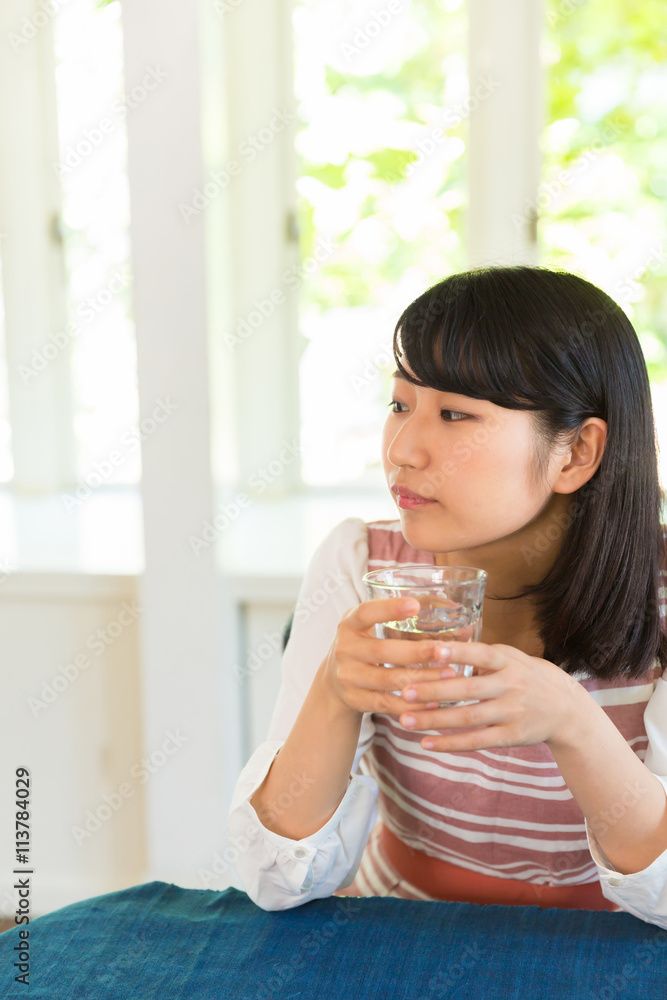 部屋で水を飲む女性 部屋で水を飲む女性