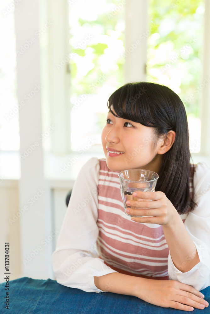 部屋で水を飲む女性 部屋で水を飲む女性