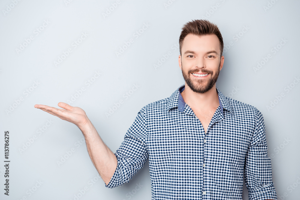 Young happy smiling businessman demonstrating his product Young happy smiling businessman demonstrating his product