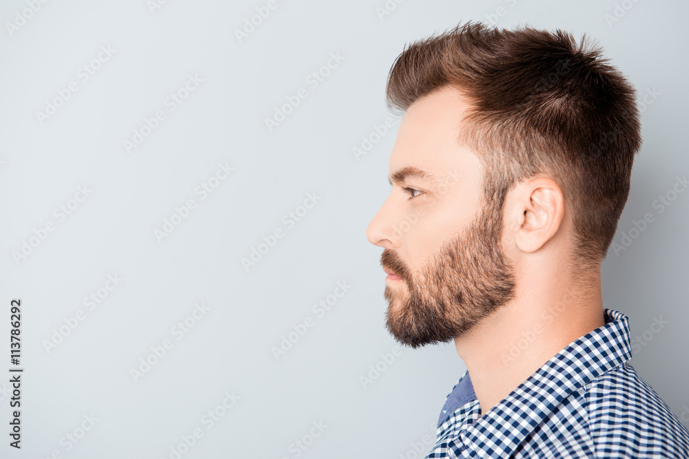 Side view of young bearded man isolated on gray background Side view of young bearded man isolated on gray background