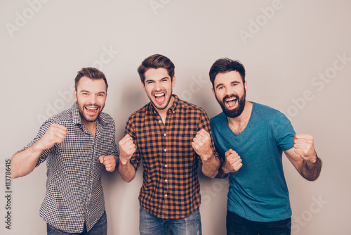 YEAH! three  handsome screaming men showing their strong hands photo