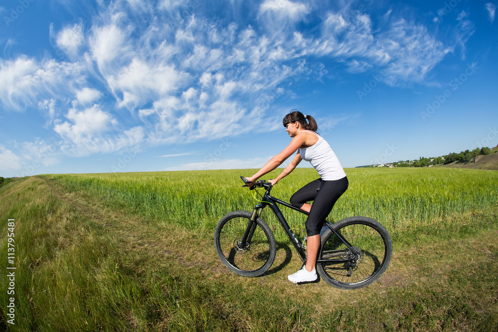 woman going for bike ride on sunny day in countryside