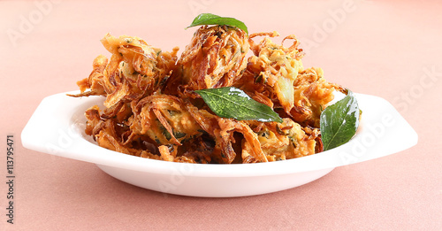 Onion Pakora, a traditional and popular Indian snack, in a tray.