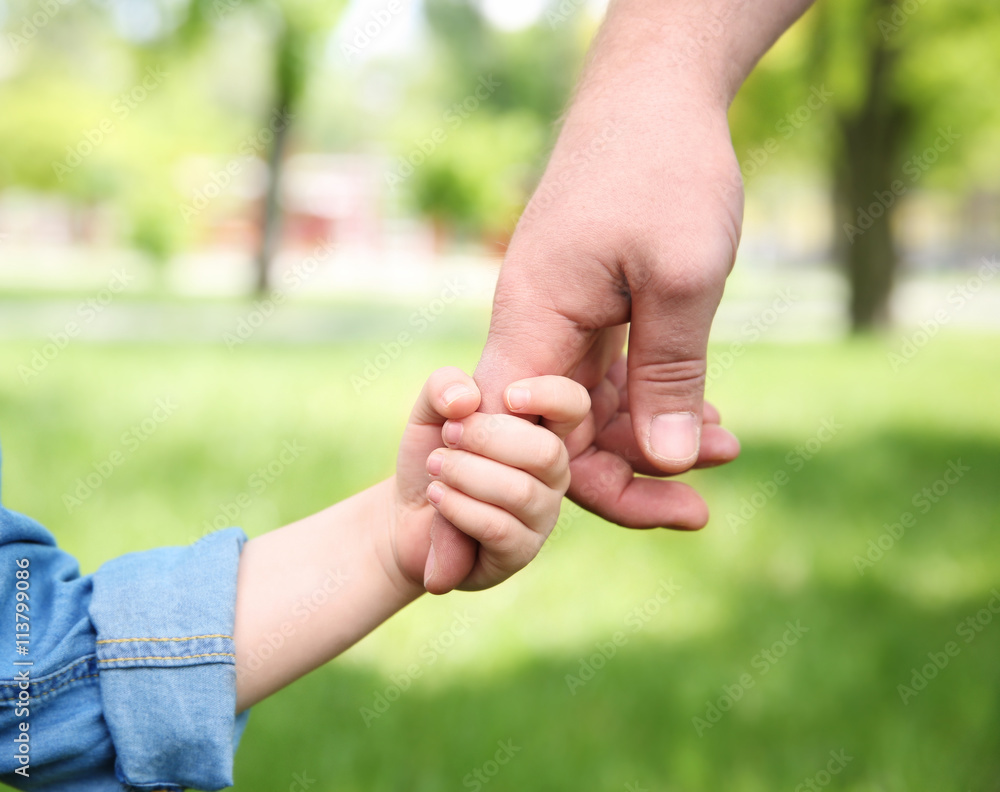 Adult and child hands on natural background Adult and child hands on natural background