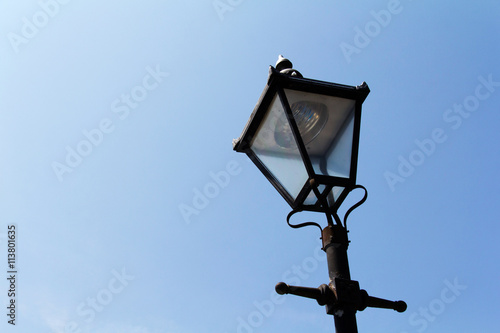 Old victorian lamp post against blue sky