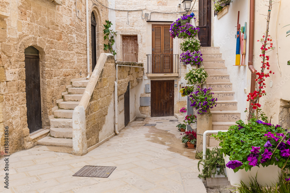 Romantic streets of Polignano a Mare old town with poems written on stairs, Apulia region, South of Italy