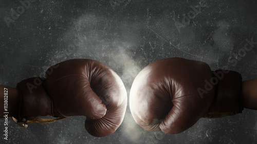 Two old brown boxing gloves hit together © Ezio Gutzemberg
