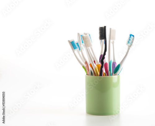 Multicolored toothbrushes in a water glass