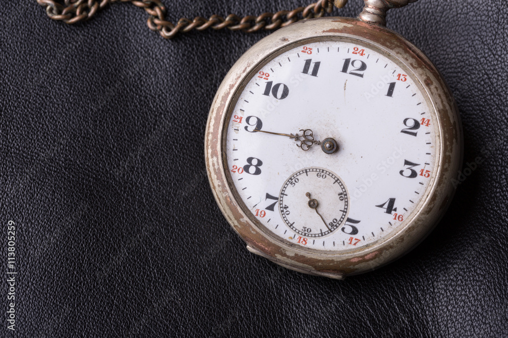 old clock on a background of black leather old clock on a background of black leather