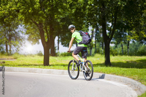 A man on a Bicycle with a backpack. © zhukovvvlad
