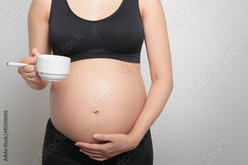 a pregnant woman smoking cigarette and drinking coffee unhealthy