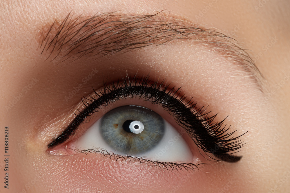 Naklejka premium Cosmetics and make-up. Beautiful female eye with sexy black liner makeup. Fashion big arrow shape on woman's eyelid. Chic evening make-up