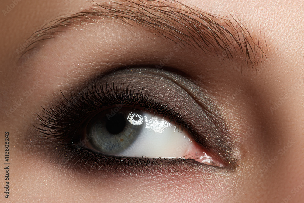 Obraz premium Macro shot of woman's beautiful eye with extremely long eyelashes. Sexy view, sensual look. Fashion smoky makeup.