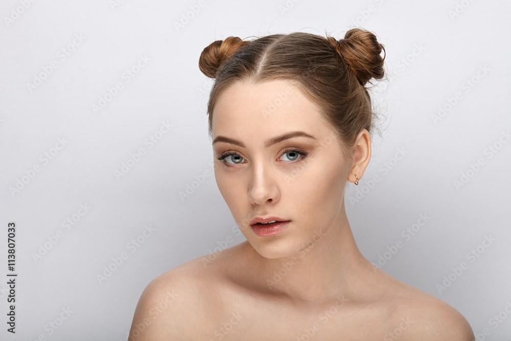 Portrait of a young woman with funny hairstyle and bare shoulders act the ape against white studio background Portrait of a young woman with funny hairstyle and bare shoulders act the ape against white studio background