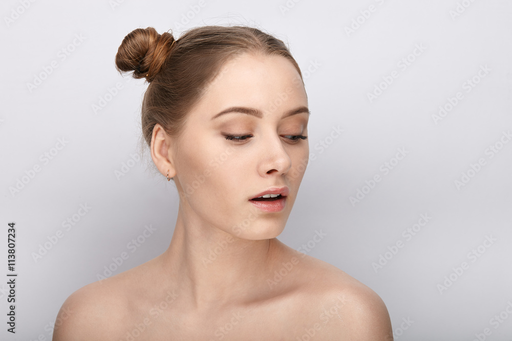 Portrait of a young woman with funny hairstyle and bare shoulders act the ape against white studio background Portrait of a young woman with funny hairstyle and bare shoulders act the ape against white studio background