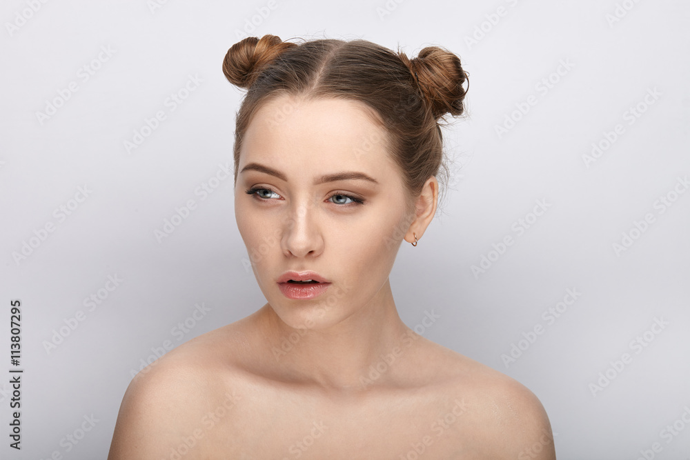Portrait of a young woman with funny hairstyle and bare shoulders act the ape against white studio background Portrait of a young woman with funny hairstyle and bare shoulders act the ape against white studio background